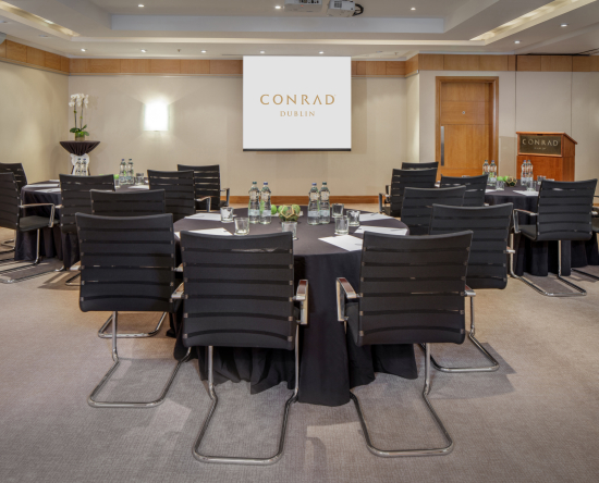 Meetingraum „Dodder Suite“ mit runden Tischen und Leinwand